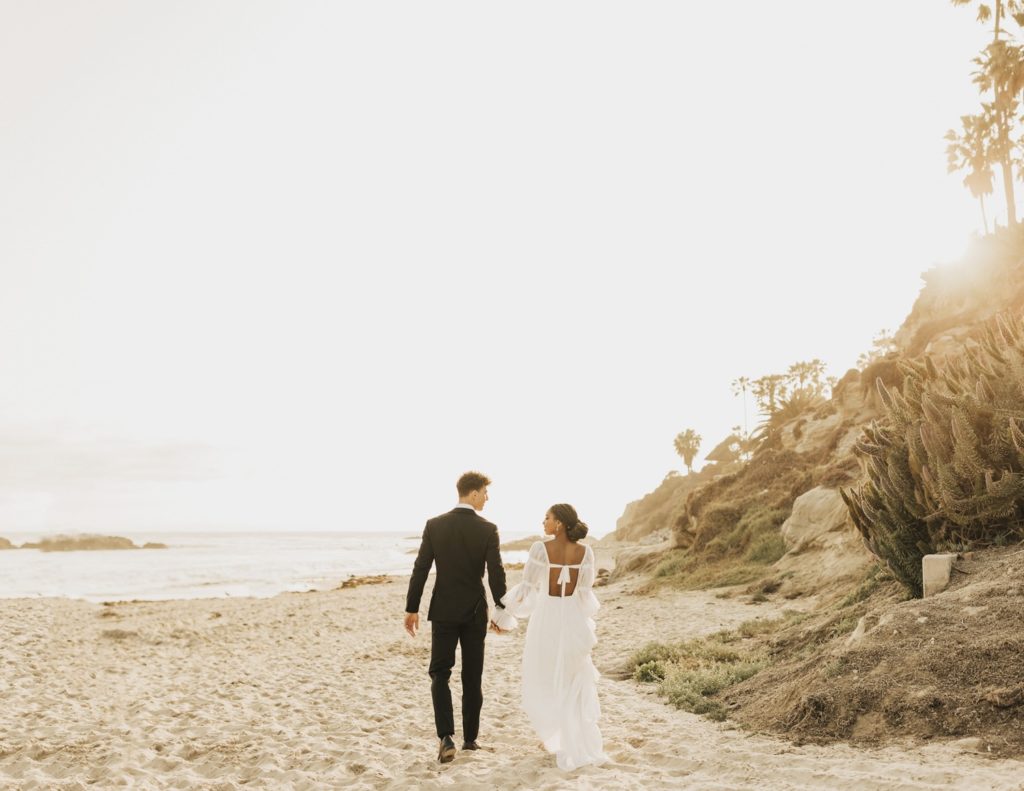bride and groom walking on laguna beach