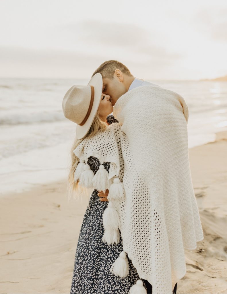 Couple wrapped in blanket in laguna beach
